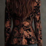 Woman wearing a black and bronze floral blazer
