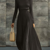Woman wearing a knitted satin dress with pleated skirt