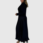 Woman wearing a maxi dress with a knit-look bodice and pleated skirt