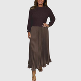 Woman wearing a maxi dress with a knit-look bodice and pleated skirt