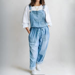 Woman wearing a loose-fit denim jumpsuit in a classic wash