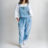 Woman wearing a loose-fit denim jumpsuit in a classic wash