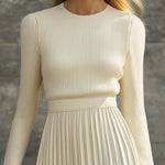 Woman wearing a knitted satin dress with pleated skirt