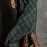 Woman wearing a full-length green plaid shirt dress with long sleeves
