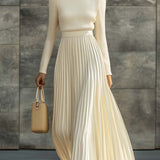 Woman wearing a knitted satin dress with pleated skirt