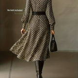 Woman wearing a rhombus print dress with belted waist