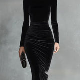 Woman wearing a black velvet fitted dress
