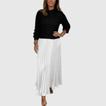 Woman wearing a maxi dress with a knit-look bodice and pleated skirt