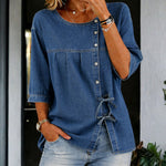 Woman wearing a long vintage-wash denim blouse with button front
