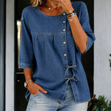 Woman wearing a long vintage-wash denim blouse with button front