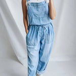 Woman wearing a loose-fit denim jumpsuit in a classic wash