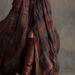 Woman wearing a belted plaid shirt dress with structured collar and flared skirt