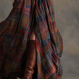 Woman wearing a belted plaid shirt dress with structured collar and flared skirt