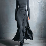 Woman wearing a long-sleeve maxi dress with an adjustable side tie