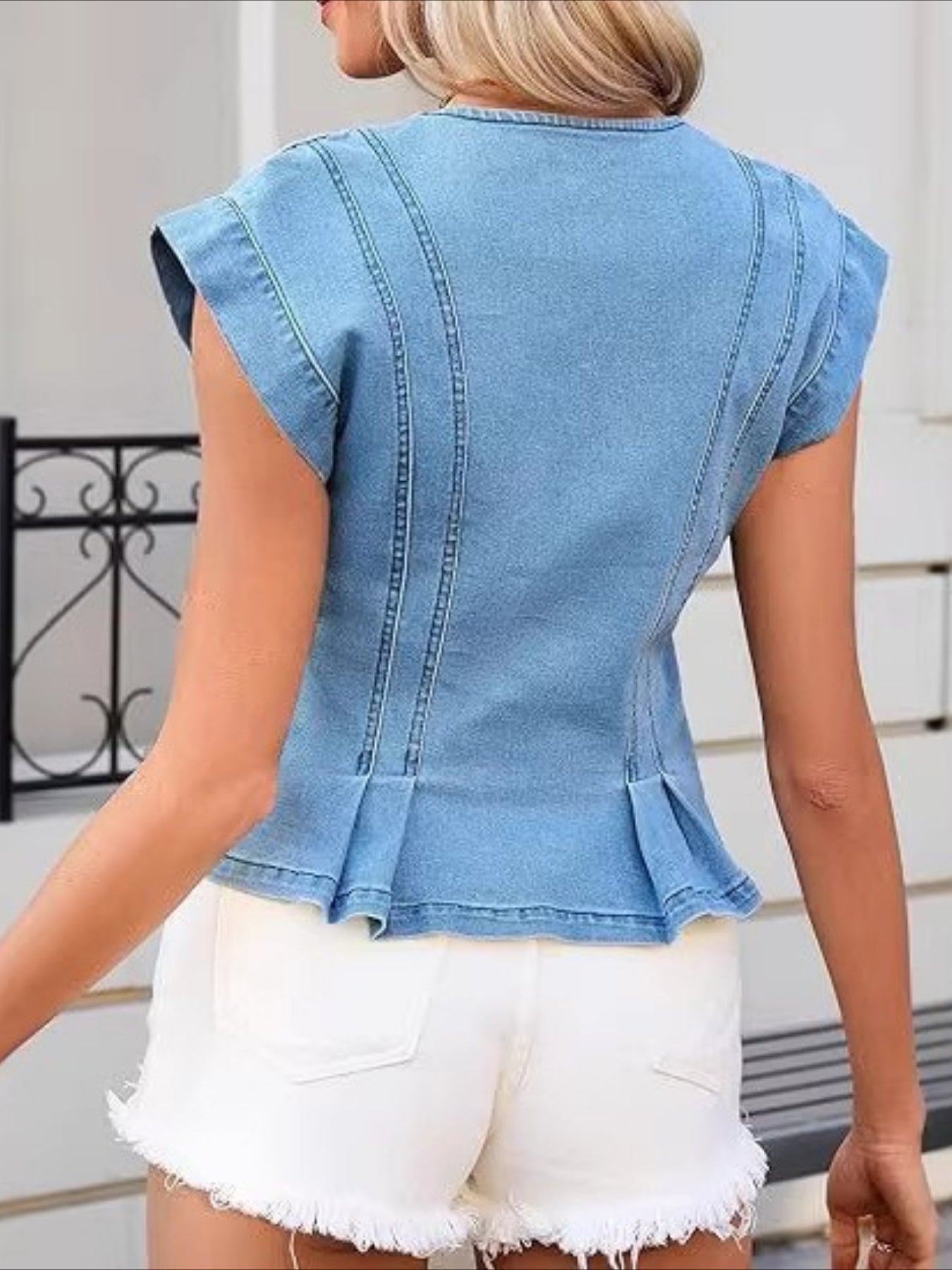 Woman wearing a sleeveless V-neck denim top