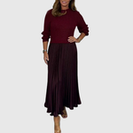 Woman wearing a maxi dress with a knit-look bodice and pleated skirt