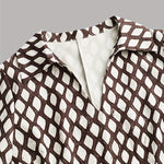 Woman wearing a rhombus print dress with belted waist