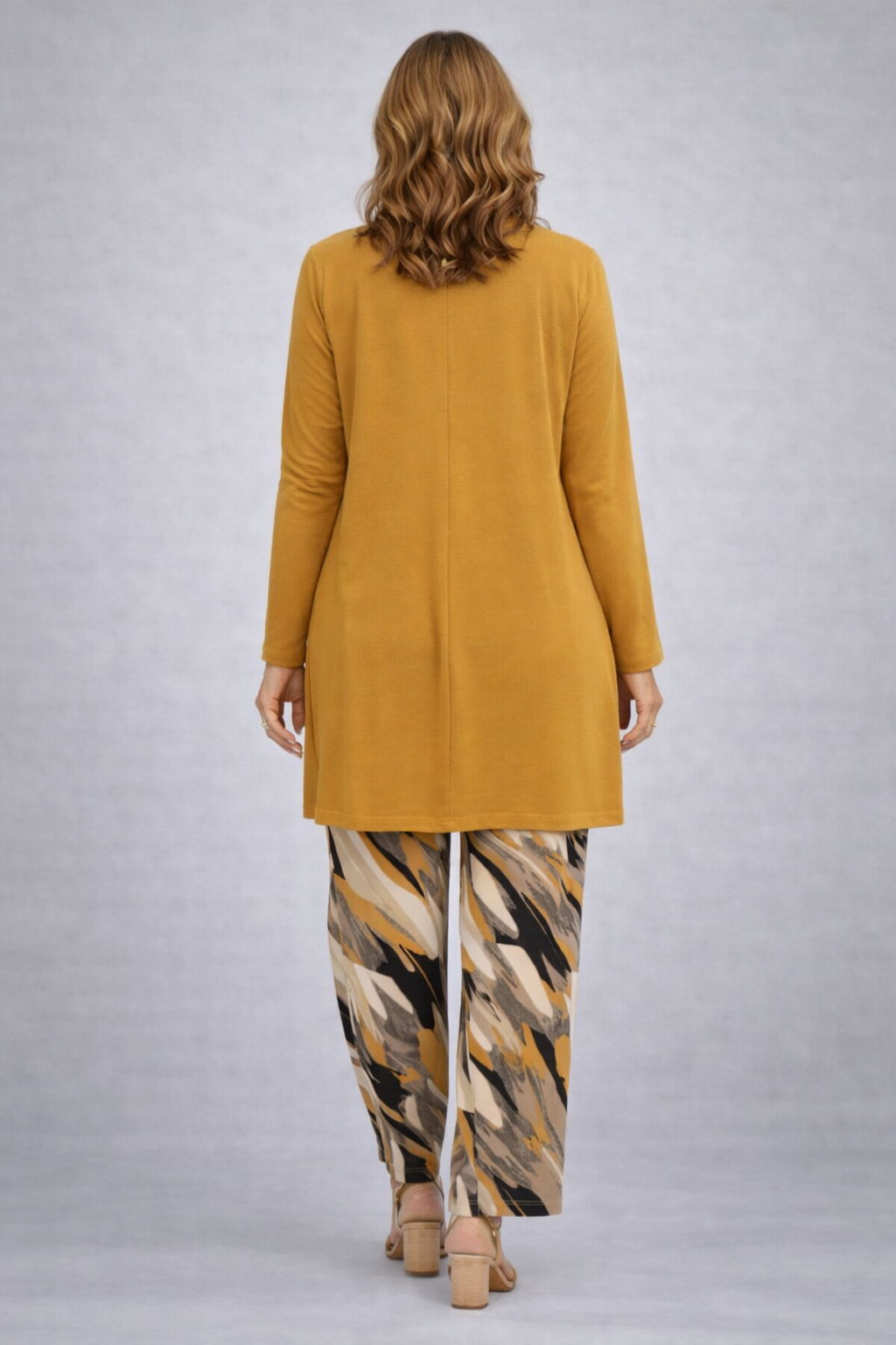 Woman wearing a yellow three-piece cardigan, top and trousers co-ord set