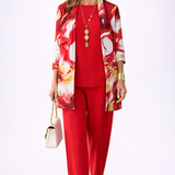 Woman wearing a red three-piece cardigan, top and trousers co-ord set