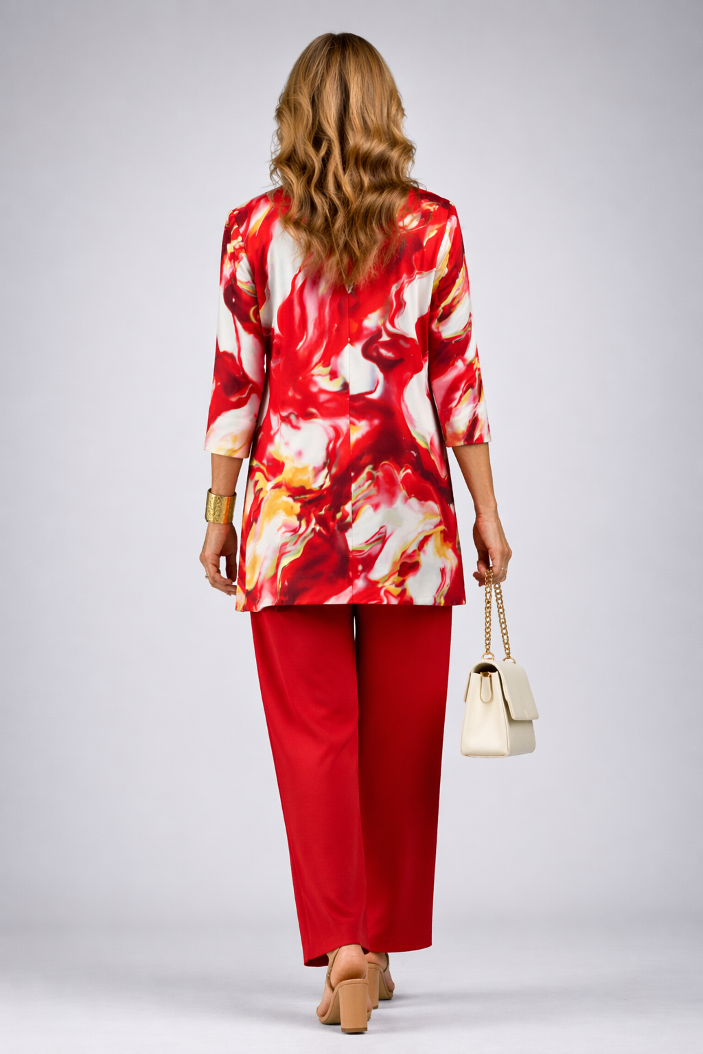 Woman wearing a red three-piece cardigan, top and trousers co-ord set