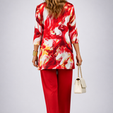 Woman wearing a red three-piece cardigan, top and trousers co-ord set