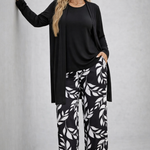 Woman wearing a monochrome three-piece cardigan, top and trousers co-ord set