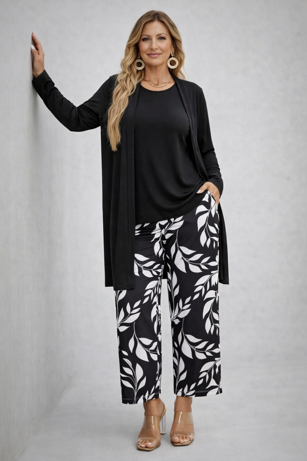 Woman wearing a monochrome three-piece cardigan, top and trousers co-ord set