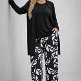 Woman wearing a monochrome three-piece cardigan, top and trousers co-ord set