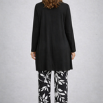 Woman wearing a monochrome three-piece cardigan, top and trousers co-ord set