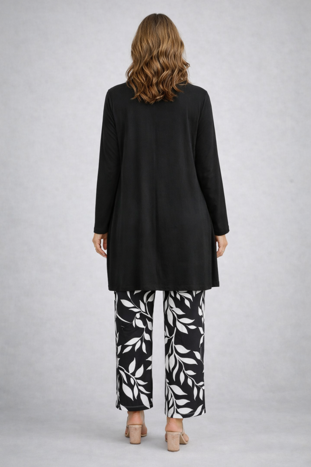 Woman wearing a monochrome three-piece cardigan, top and trousers co-ord set