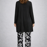 Woman wearing a monochrome three-piece cardigan, top and trousers co-ord set