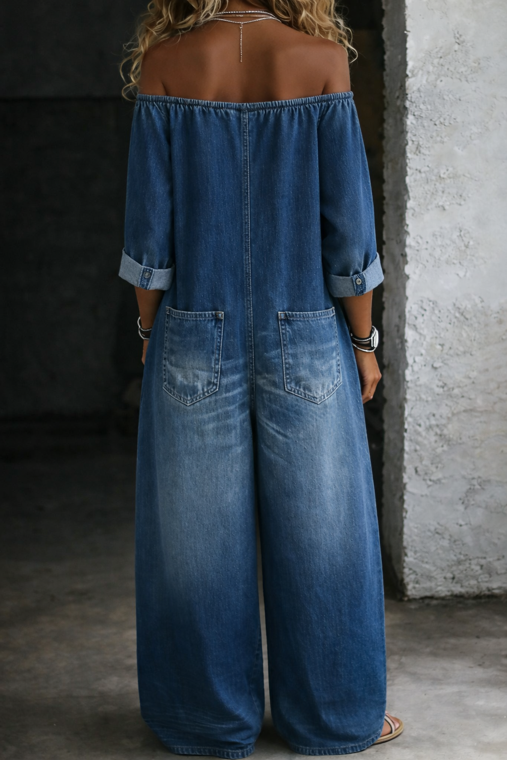 Woman wearing a long-sleeve off-shoulder denim jumpsuit