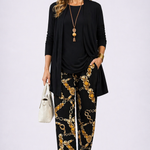 Woman wearing a black and gold three-piece cardigan, top and trousers co-ord set