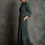 Woman wearing a full-length green plaid shirt dress with long sleeves