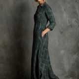 Woman wearing a full-length green plaid shirt dress with long sleeves