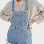 Woman wearing classic denim dungaree shorts with front pocket