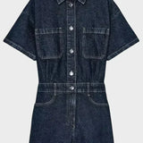 Woman wearing denim dungarees with front button fastening