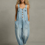 Woman wearing a wide-leg denim jumpsuit with adjustable straps and front pockets