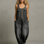 Woman wearing a wide-leg denim jumpsuit with adjustable straps and front pockets