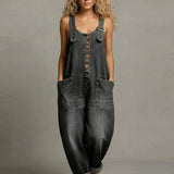 Woman wearing a wide-leg denim jumpsuit with adjustable straps and front pockets