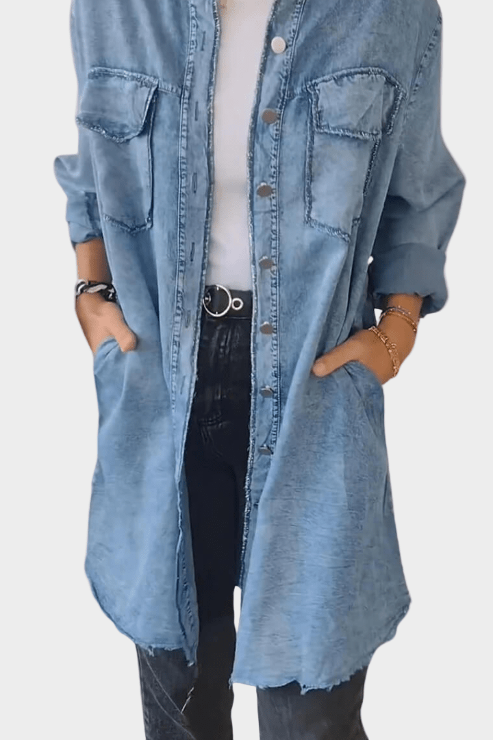 Woman wearing a long denim shirt dress with rolled sleeves and side pockets