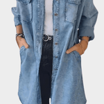 Woman wearing a long denim shirt dress with rolled sleeves and side pockets