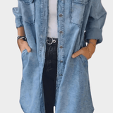 Woman wearing a long denim shirt dress with rolled sleeves and side pockets