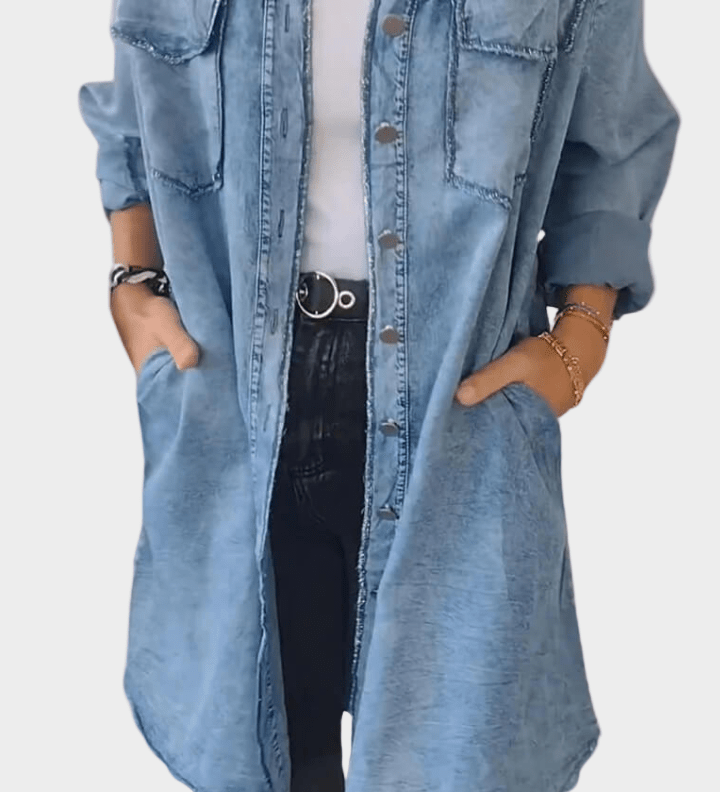 Woman wearing a long denim shirt dress with rolled sleeves and side pockets