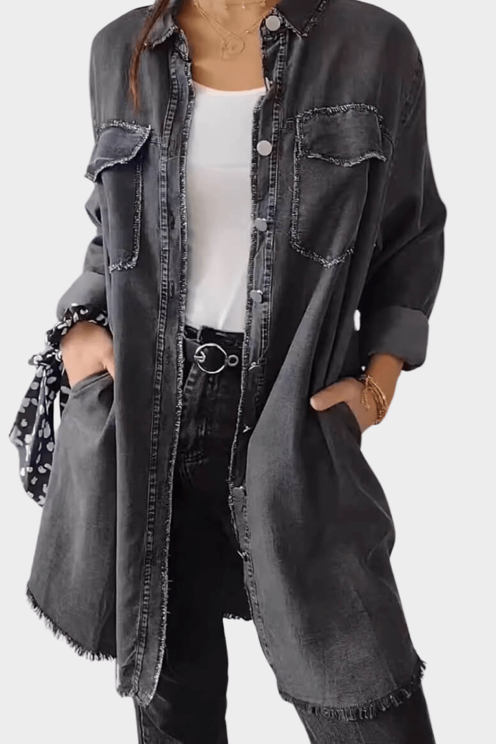 Woman wearing a long denim shirt dress with rolled sleeves and side pockets