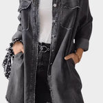 Woman wearing a long denim shirt dress with rolled sleeves and side pockets