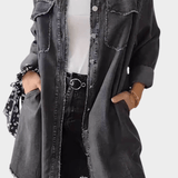 Woman wearing a long denim shirt dress with rolled sleeves and side pockets