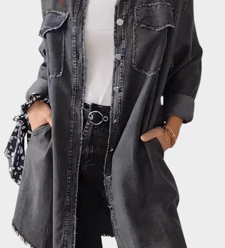 Woman wearing a long denim shirt dress with rolled sleeves and side pockets