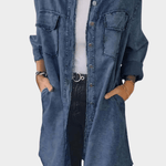 Woman wearing a long denim shirt dress with rolled sleeves and side pockets