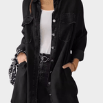 Woman wearing a long denim shirt dress with rolled sleeves and side pockets